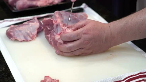 Man Cutting and trimming Large Pork Meat In A Kitchen With Two Knives Stock Footage 140601771