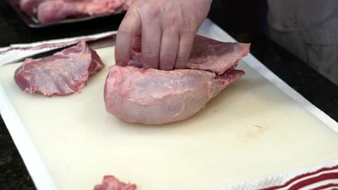 Man Cutting and trimming Large Pork Meat In A Kitchen With Two Knives Stock Footage 140601825