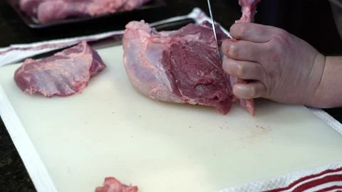 Man Cutting and trimming Large Pork Meat In A Kitchen With Two Knives Stock Footage 140602303
