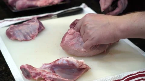 Man Cutting and trimming Large Pork Meat In A Kitchen With Two Knives Stock Footage 140602495