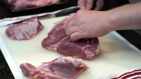 Man Cutting and trimming Large Pork Meat In A Kitchen With Two Knives Stock Footage 140602664