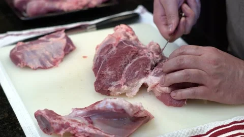 Man Cutting and trimming Large Pork Meat In A Kitchen With Two Knives Stock Footage 140602936