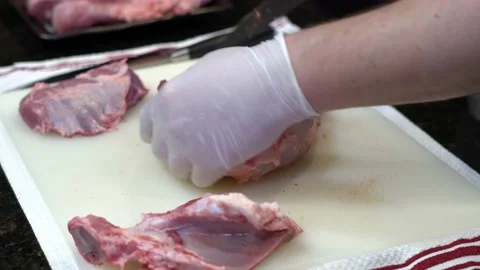 Man Cutting and trimming Large Pork Meat In A Kitchen With Two Knives Stock Footage 140602977