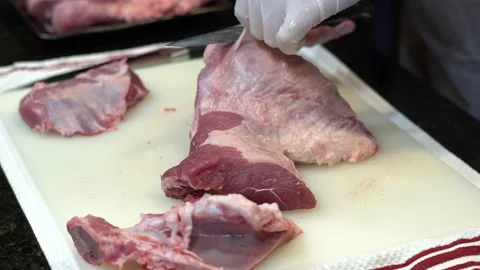 Man Cutting and trimming Large Pork Meat In A Kitchen With Two Knives Stock Footage 140603087