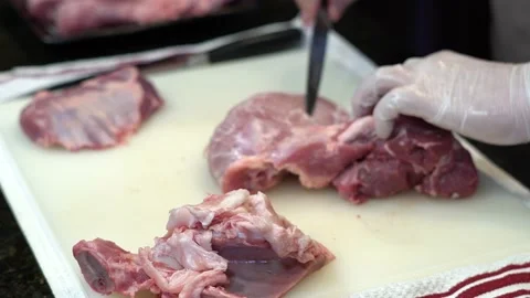 Man Cutting and trimming Large Pork Meat In A Kitchen With Two Knives Stock Footage 140607048