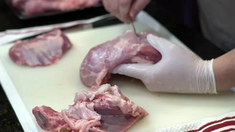 Man Cutting and trimming Large Pork Meat In A Kitchen With Two Knives Stock Footage 140607066