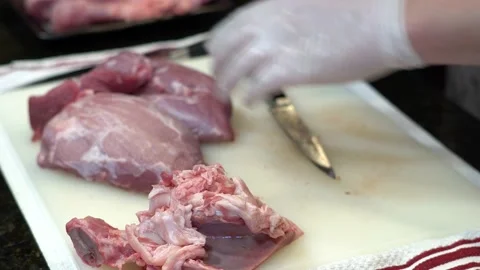 Man Cutting and trimming Large Pork Meat In A Kitchen With Two Knives Stock Footage 140607374