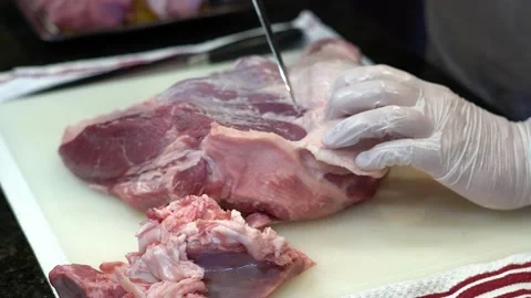 Man Cutting and trimming Large Pork Meat In A Kitchen With Two Knives Stock Footage 140607612
