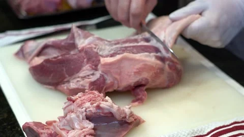 Man Cutting and trimming Large Pork Meat In A Kitchen With Two Knives Stock Footage 140607647