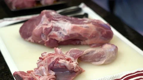 Man Cutting and trimming Large Pork Meat In A Kitchen With Two Knives Stock Footage 140608040