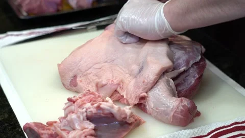 Man Cutting and trimming Large Pork Meat In A Kitchen With Two Knives Stock Footage 140608100