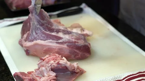 Man Cutting and trimming Large Pork Meat In A Kitchen With Two Knives Stock Footage 140608145