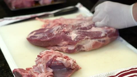 Man Cutting and trimming Large Pork Meat In A Kitchen With Two Knives Stock Footage 140608512