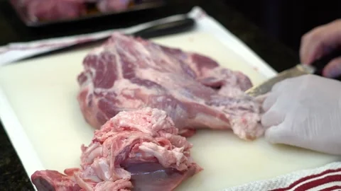 Man Cutting and trimming Large Pork Meat In A Kitchen With Two Knives Video stock 140608880