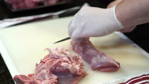 Man Cutting and trimming Large Pork Meat In A Kitchen With Two Knives Stock Footage 140608971