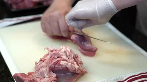 Man Cutting and trimming Large Pork Meat In A Kitchen With Two Knives Stock Footage 140609121
