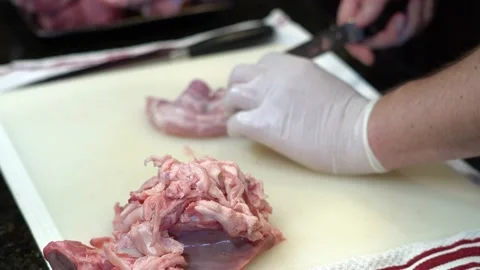 Man Cutting and trimming Large Pork Meat In A Kitchen With Two Knives Video stock 140609197