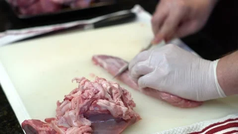 Man Cutting and trimming Large Pork Meat In A Kitchen With Two Knives Video stock 140609216