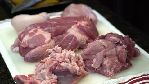 Man Cutting and trimming Large Pork Meat In A Kitchen With Two Knives Video stock 140609640