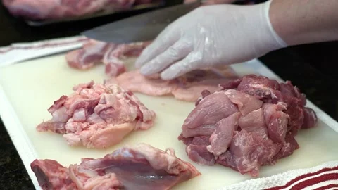 Man Cutting and trimming Large Pork Meat In A Kitchen With Two Knives Video stock 140609699