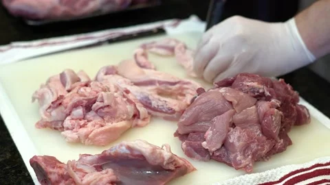 Man Cutting and trimming Large Pork Meat In A Kitchen With Two Knives Video stock 140609702