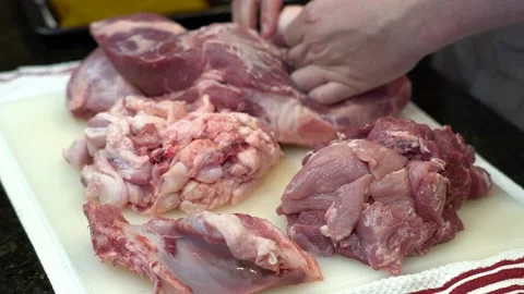 Man Cutting and trimming Large Pork Meat In A Kitchen With Two Knives Stock Footage 140609743