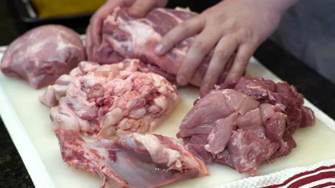 Man Cutting and trimming Large Pork Meat In A Kitchen With Two Knives Stock Footage 140609762