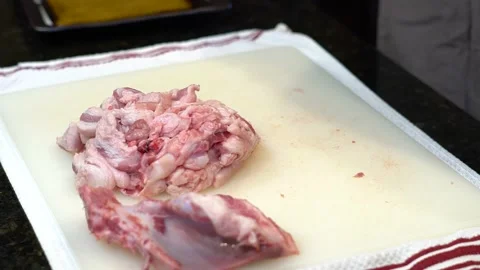 Man Cutting and trimming Large Pork Meat In A Kitchen With Two Knives Video stock 140609924