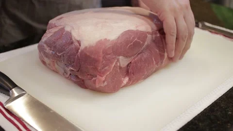 Man Cutting and trimming Large Pork Meat In A Kitchen With Two Knives Stock Footage 140610015