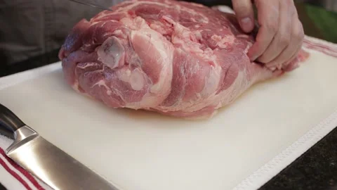 Man Cutting and trimming Large Pork Meat In A Kitchen With Two Knives Stock Footage 140610030