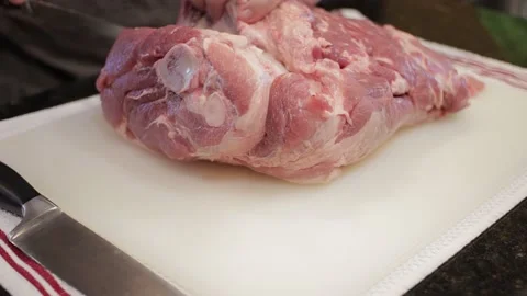 Man Cutting and trimming Large Pork Meat In A Kitchen With Two Knives Video stock 140610114