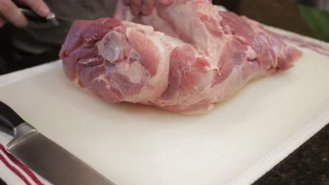 Man Cutting and trimming Large Pork Meat In A Kitchen With Two Knives Stock Footage 140610304