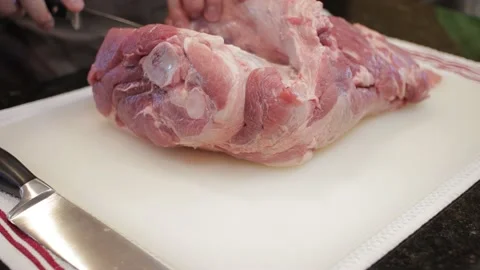 Man Cutting and trimming Large Pork Meat In A Kitchen With Two Knives Stock Footage 140610344
