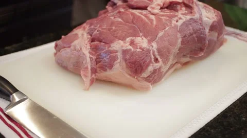 Man Cutting and trimming Large Pork Meat In A Kitchen With Two Knives Stock Footage 140610441
