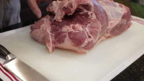 Man Cutting and trimming Large Pork Meat In A Kitchen With Two Knives Stock Footage 140610569