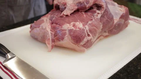 Man Cutting and trimming Large Pork Meat In A Kitchen With Two Knives Stock Footage 140610619