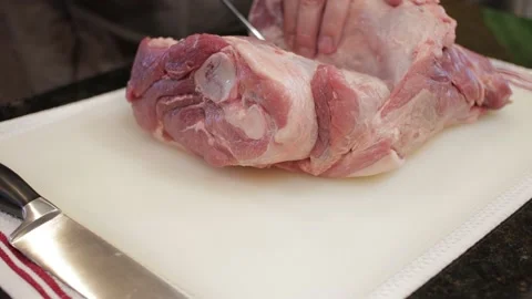 Man Cutting and trimming Large Pork Meat In A Kitchen With Two Knives Stock Footage 140610746