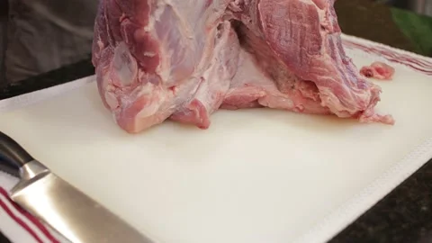 Man Cutting and trimming Large Pork Meat In A Kitchen With Two Knives Stock Footage 140610839