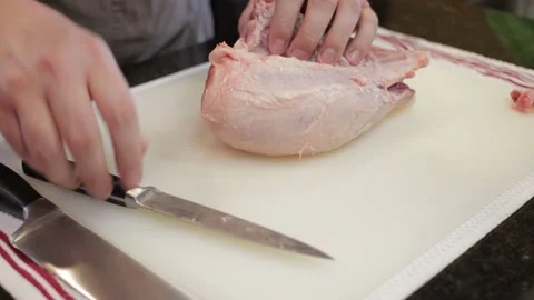 Man Cutting and trimming Large Pork Meat In A Kitchen With Two Knives Stock Footage 140612503
