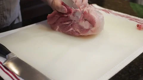 Man Cutting and trimming Large Pork Meat In A Kitchen With Two Knives Video stock 140612507