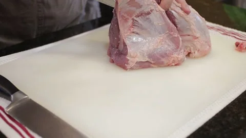 Man Cutting and trimming Large Pork Meat In A Kitchen With Two Knives Video stock 140612761