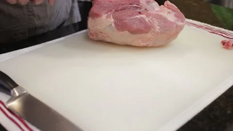 Man Cutting and trimming Large Pork Meat In A Kitchen With Two Knives Video stock 140613175