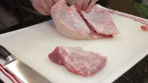 Man Cutting and trimming Large Pork Meat In A Kitchen With Two Knives Stock Footage 140613791