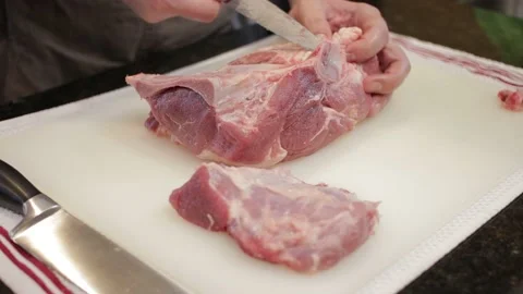 Man Cutting and trimming Large Pork Meat In A Kitchen With Two Knives Stock Footage 140613802
