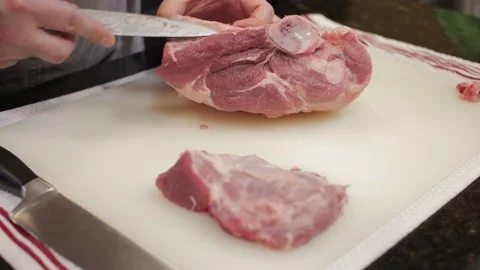 Man Cutting and trimming Large Pork Meat In A Kitchen With Two Knives Stock Footage 140613822