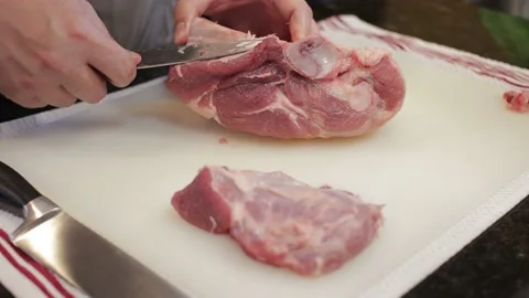 Man Cutting and trimming Large Pork Meat In A Kitchen With Two Knives Stock Footage 140613828