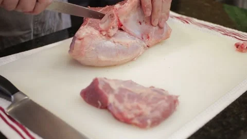 Man Cutting and trimming Large Pork Meat In A Kitchen With Two Knives Stock Footage 140614136