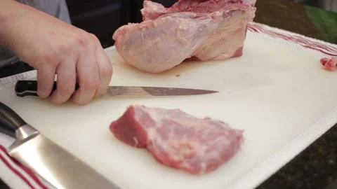 Man Cutting and trimming Large Pork Meat In A Kitchen With Two Knives Video stock 140614151