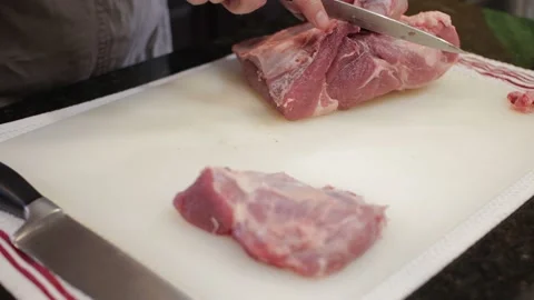 Man Cutting and trimming Large Pork Meat In A Kitchen With Two Knives Video stock 140614170