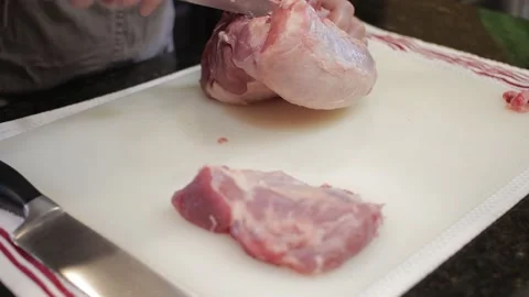 Man Cutting and trimming Large Pork Meat In A Kitchen With Two Knives Stock Footage 140614176